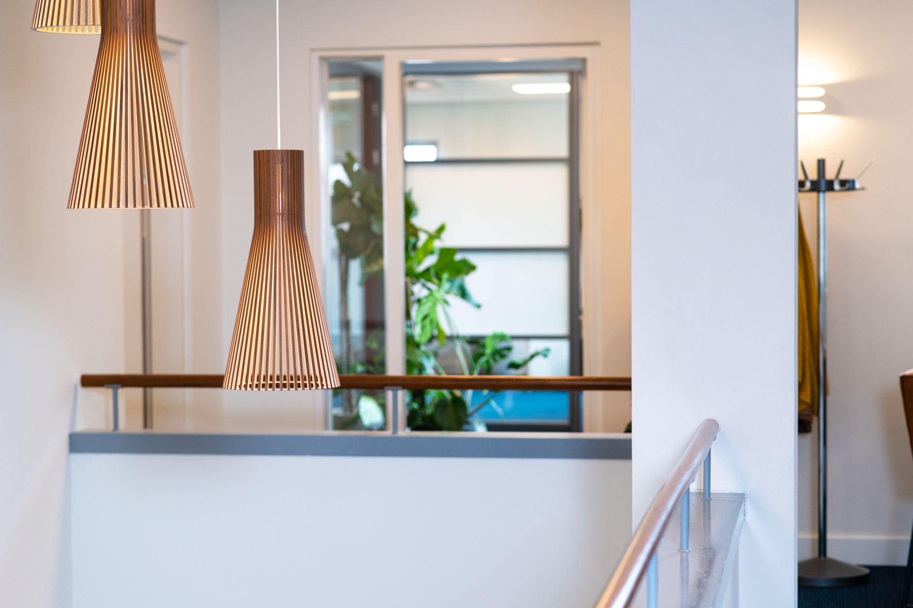 Contemporary interior with turned-timber pendant lamps and a minimalist room divider.